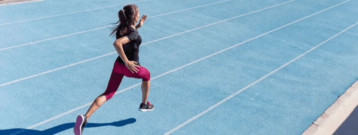 athlete running on a blue track