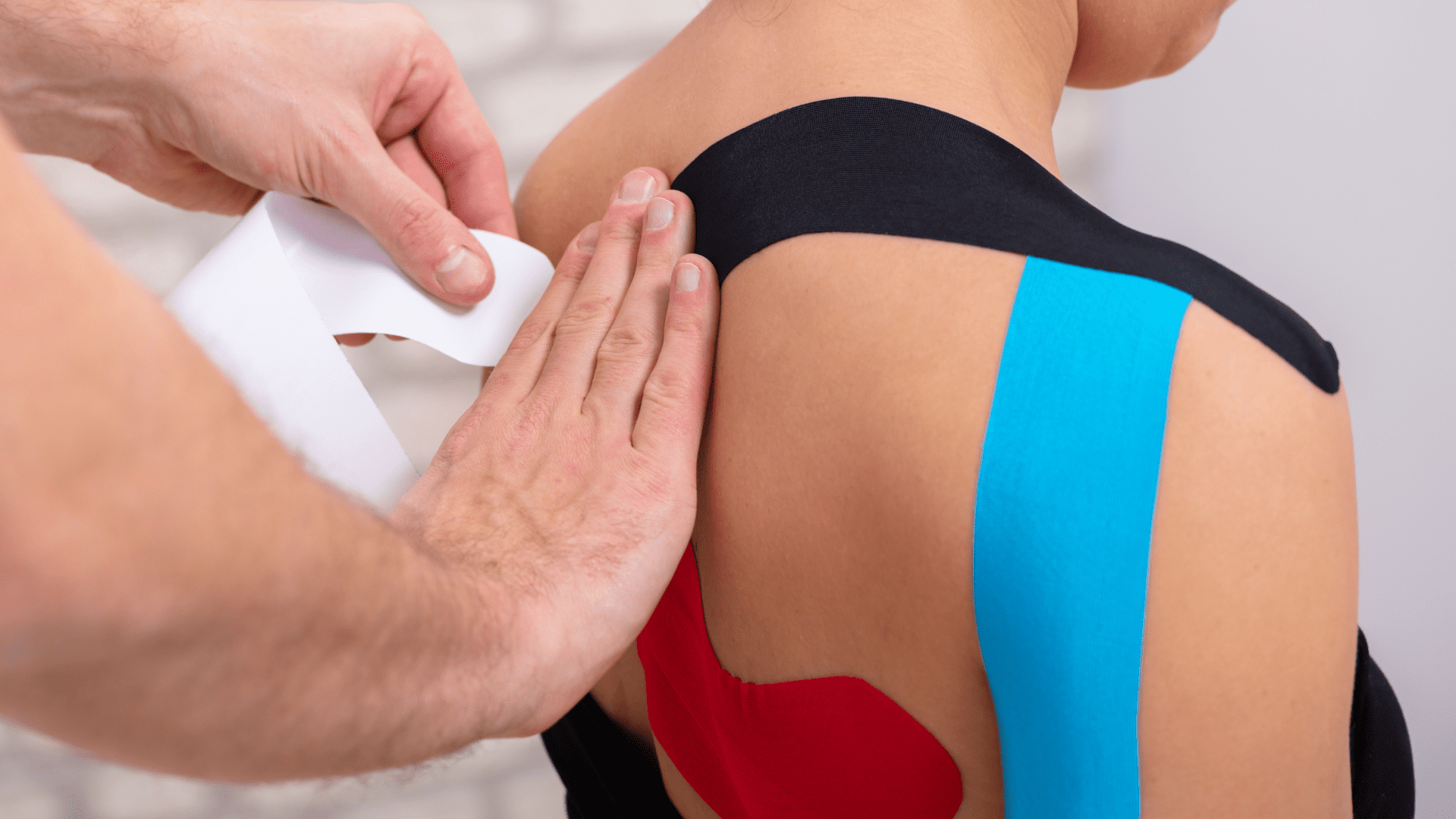 Physiotherapist applying Tape to womans shoulder