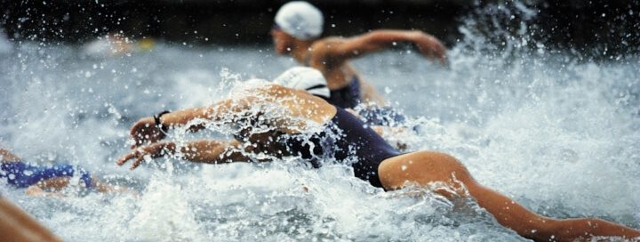 Competitive swimmers emerging from water