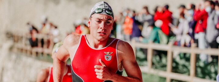 Man in red lycra running on beachfront