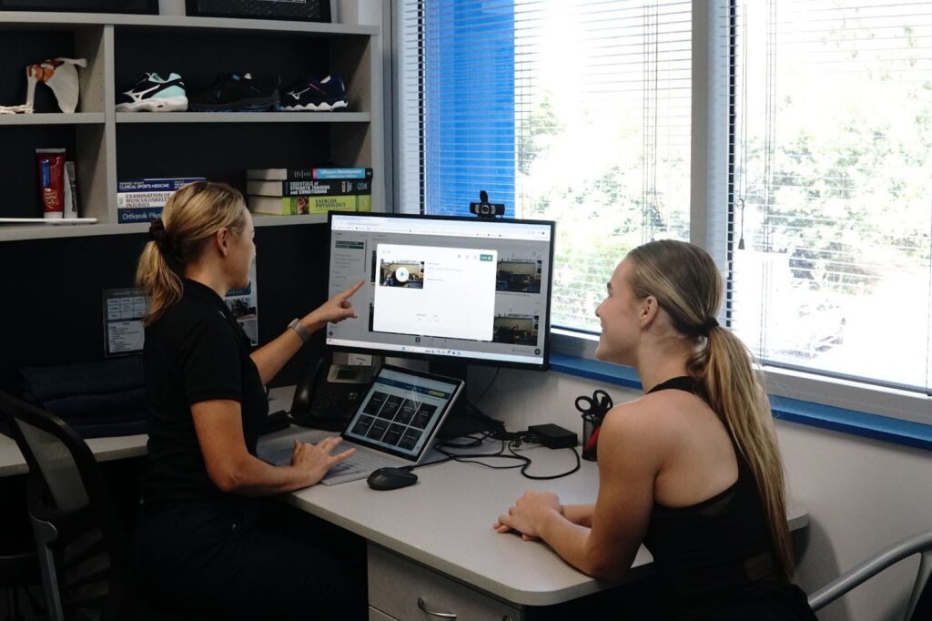 two woman in front a desktop