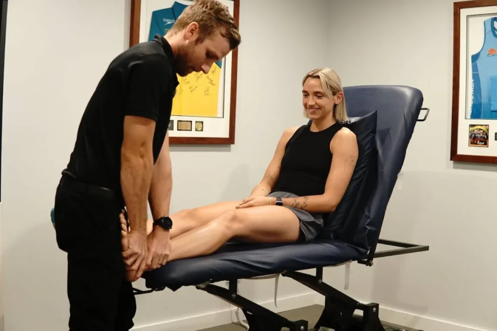 Physical therapist examining a female patient's foot.